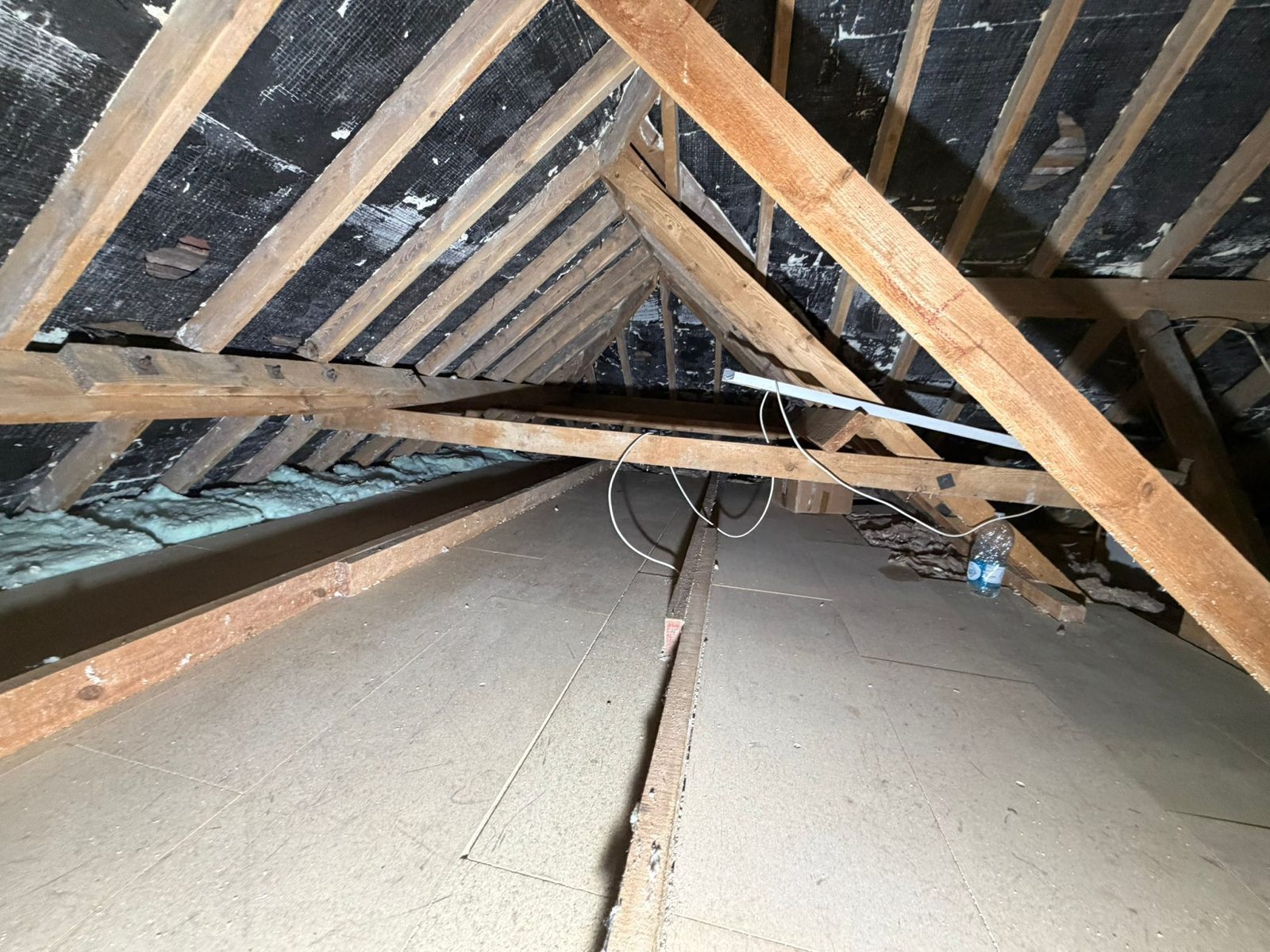 A loft floor boarded over the joists, with the trusses and sarking felt above