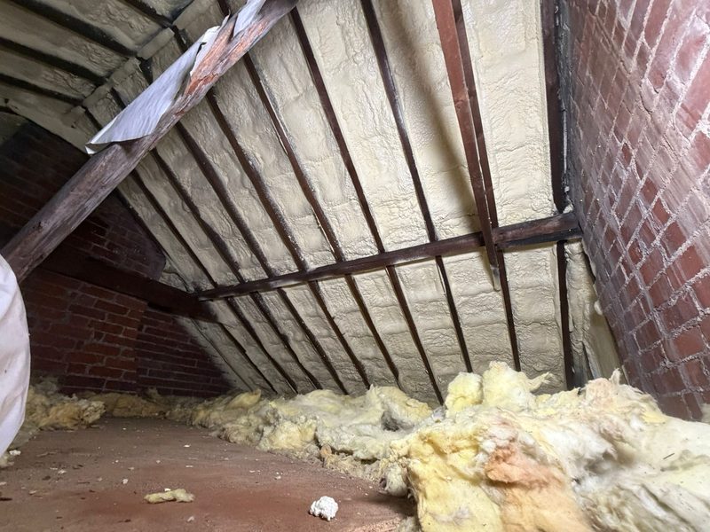 Roof rafters with spray foam removed, timbers exposed