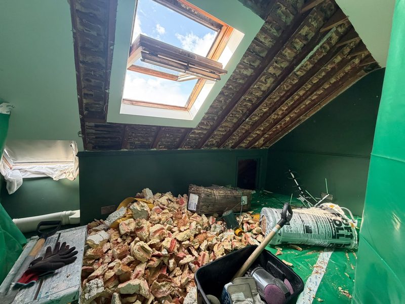 The same loft with the rafters stripped back and the removed foam piled on the floor