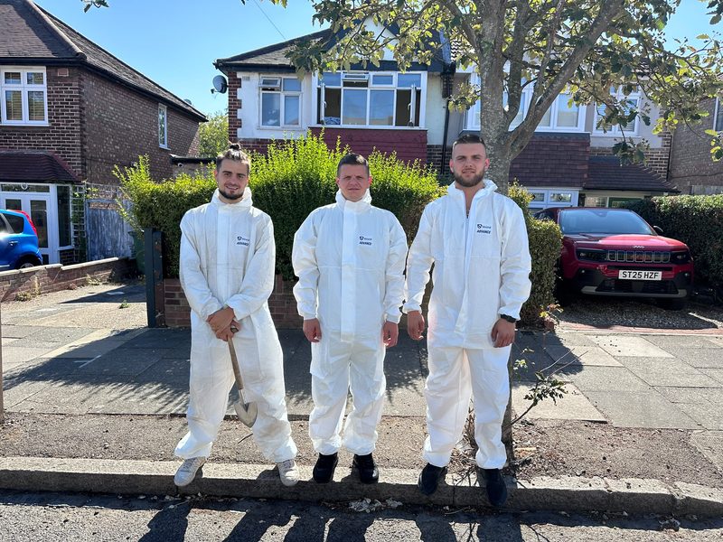 The three-man Apex crew in white overalls standing outside a customer's house